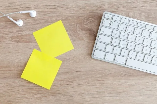 sticky notes beside a computer keyboard for who invented post-it notes