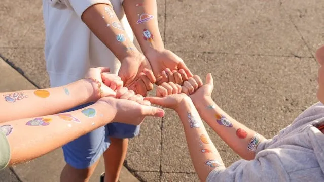 children showing their temporary tattoos for how to remove temporary tattoos