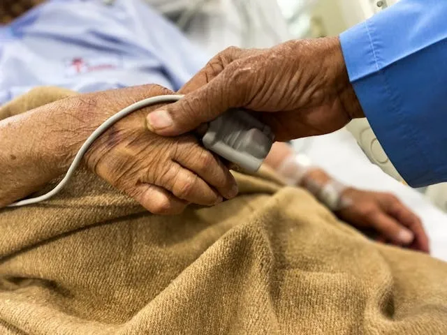 an elderly couple holding hands in hospital for yellow wristband hospital