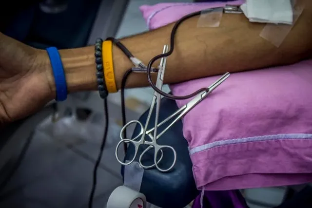 forceps and tubing on a person’s arm for yellow wristband hospital