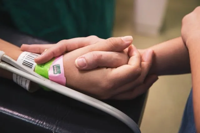 holding hands with a patient for yellow wristband hospital