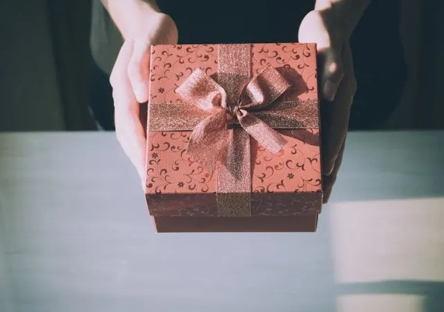 hands holding a brown gift box for best barware gifts