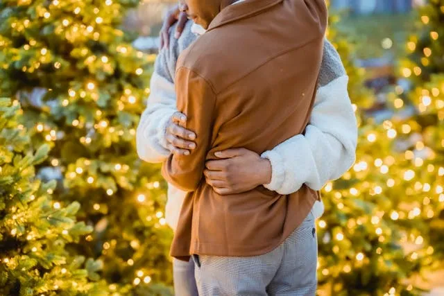 a couple embracing near christmas trees for christmas proposal ideas
