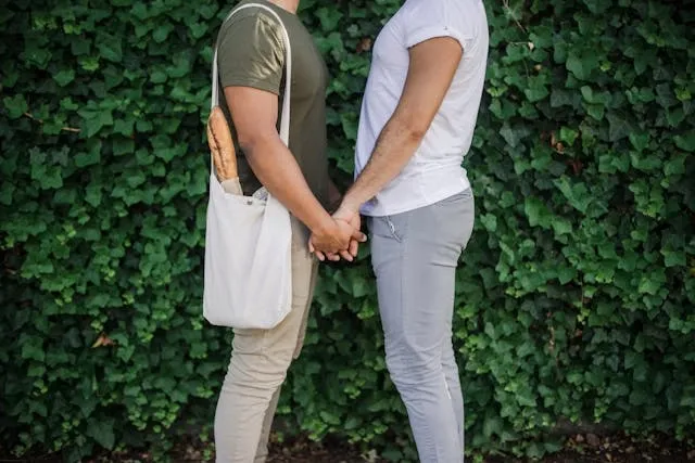 two people holding hands in front of foliage for how to store reusable shopping bags
