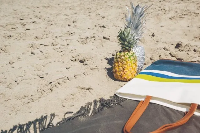 a tote bag and pineapples on sand for how to customize a tote bag