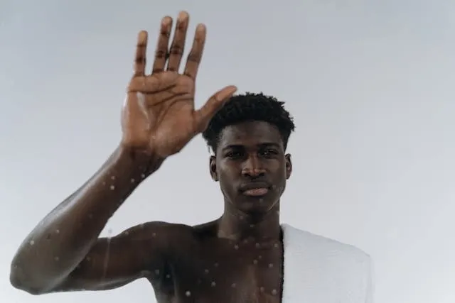 a person with a wet towel on their shoulder for how to get mildew smell out of towels