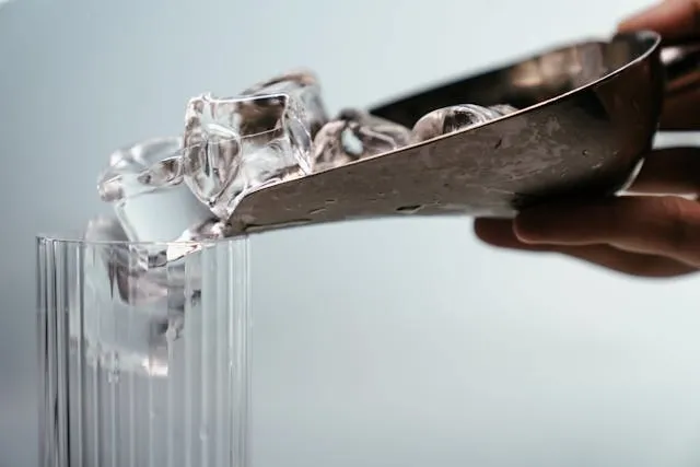a person putting ice in a glass for best bar tools