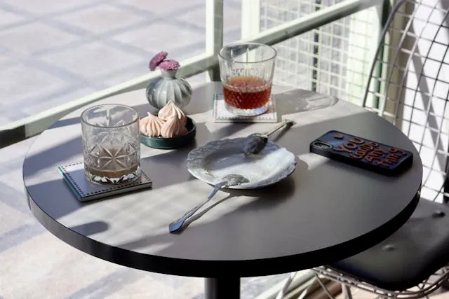 a small round table with an empty plate and drink glasses for ceramic coaster ideas