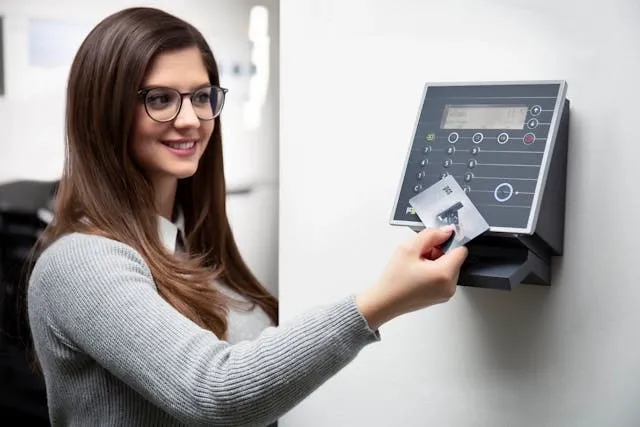 a person holding an access card over a reader for id card size