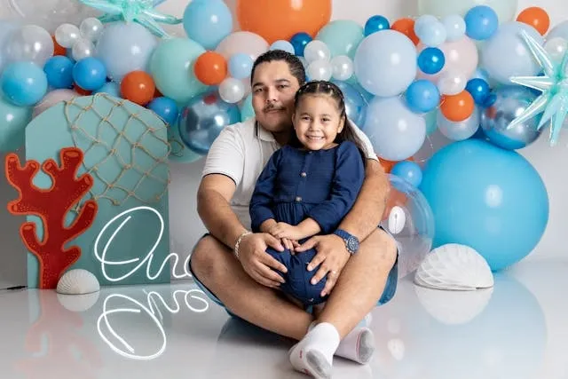 a father and daughter with colorful balloons for how to make a balloon garland