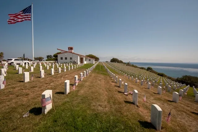 graves in a field with american flags for coins on military graves