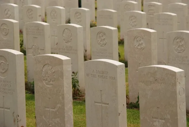 rows of tomb stones in a cemetery during the day for coins on military graves