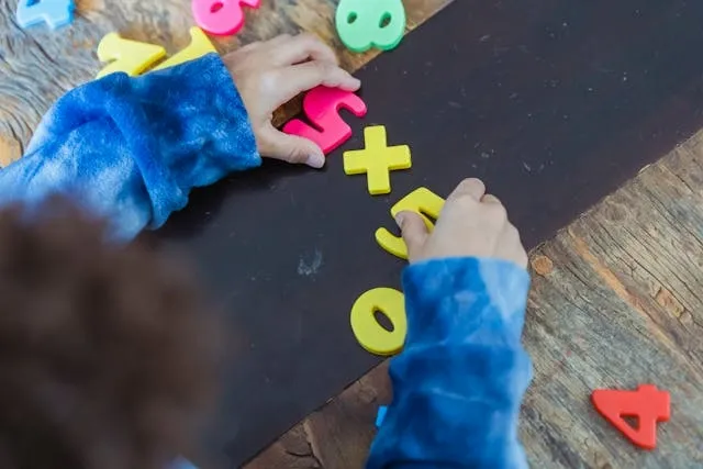 a child playing with toy magnetic numbers for do magnets stick to stainless steel