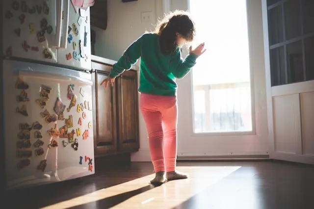 a child beside a fridge covered in magnets for what objects do magnets stick to