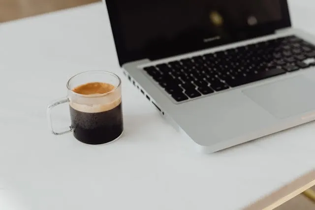 a glass mug of coffee beside a laptop for can you put hot coffee in a glass cup