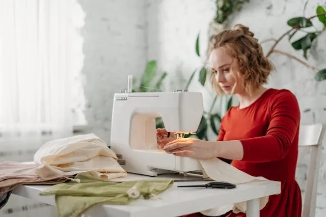 someone using a sewing machine while sitting in a chair for how to make a table runner