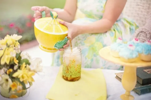 a person pouring tea outdoors for garden tea party