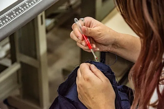 a person using a seam ripper for how to remove an embroidered patch from a jacket