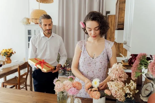 two people beside a floral arrangement for simple valentine table decorations