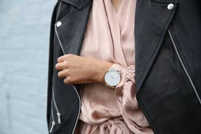 a person wearing a peach dress and black jacket with a wristwatch for gifts for fashion lovers