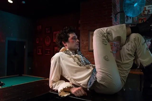 a person wearing flamboyant clothing while laying on a wooden surface for embroidery on clothes ideas