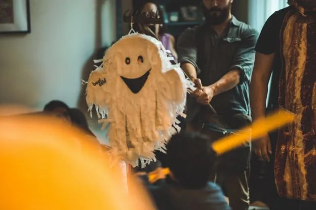 a person holding a ghost pinata for halloween table top decor