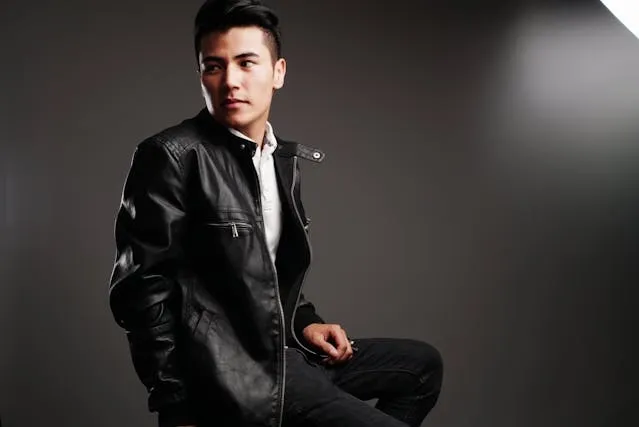 a person wearing a black leather full-zip jacket for how to style a moto jacket