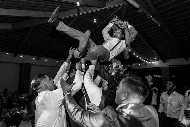 black and white photo of a group of people lifting someone into the air for bachelor party decorations