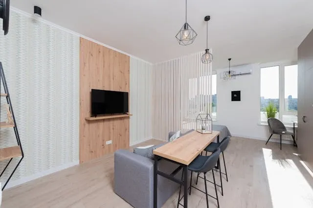 an apartment with table chairs and couch near a tv for tv wall ideas