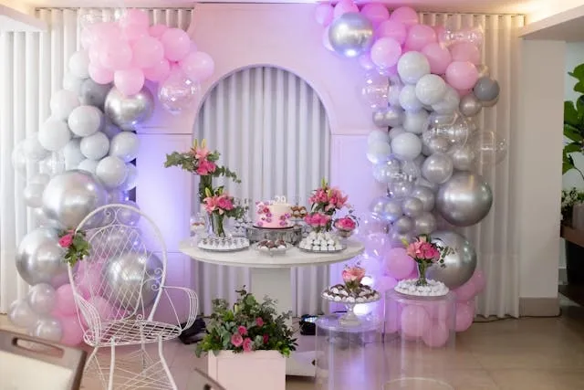 a dessert table beside a pink and purple backdrop for birthday backdrop ideas