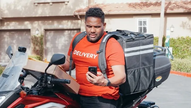 a delivery driver sitting on a motorcycle for how much weight can a backpack hold