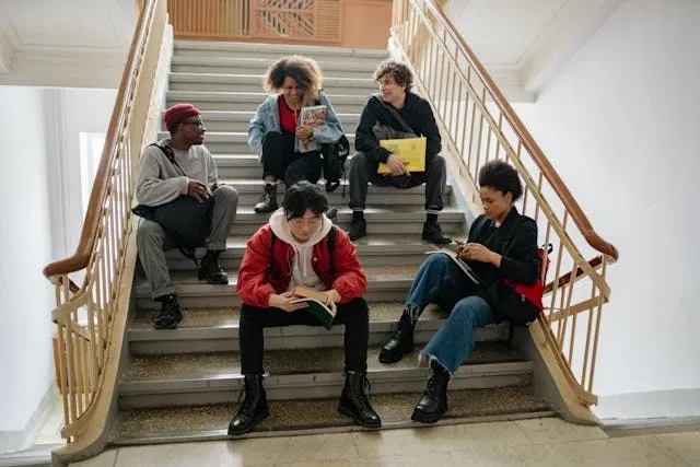 a group of college students sitting on a staircase for how to store backpacks