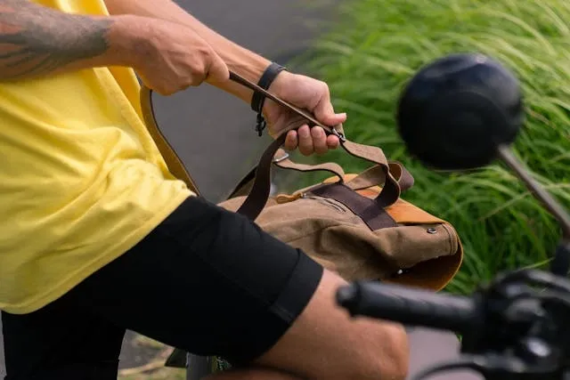 a person in a yellow shirt adjusting the strap of their backpack