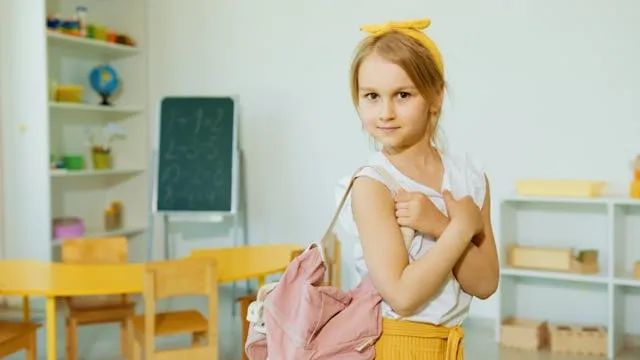 a child in a classroom carrying a pink backpack for how to store backpacks