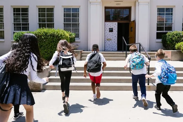 a back view of students running to their class for how to choose a backpack