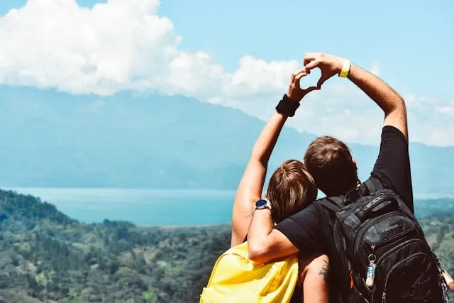 two people forming a heart hand shape for how to tighten backpack straps