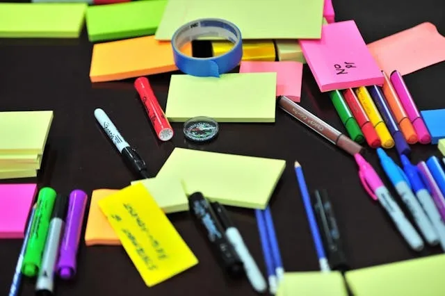 a range of different pen types on a desk with post-its for fountain pen vs ballpoint