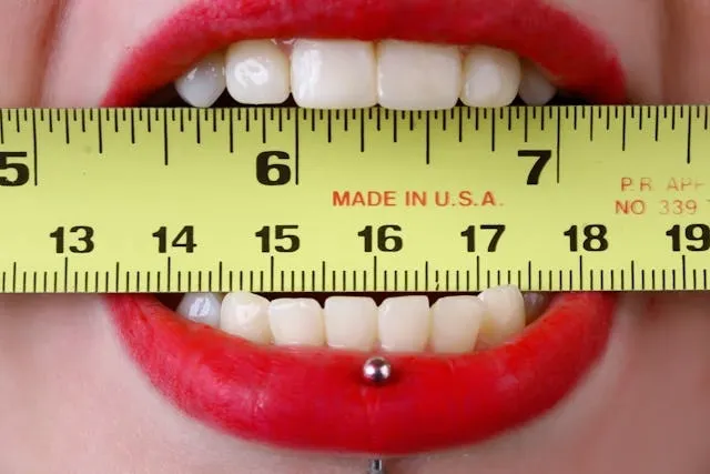 a yellow tape measure between someone’s teeth for how to measure a poly mailer for shipping