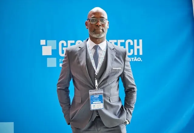 a person in a gray suit standing in front of a blue wall for best tradeshow giveaways
