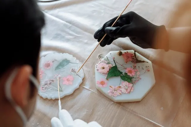people arranging dry flowers in resin for how to make resin coasters with flowers