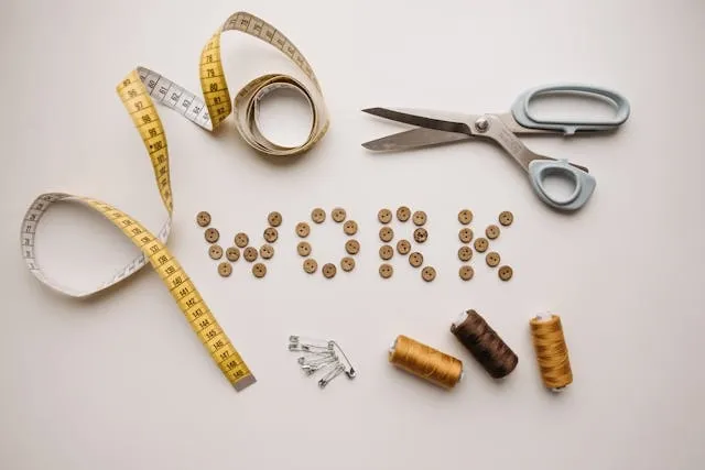a selection of sewing tools on a white surface for how to sew a patch on a uniform by hand
