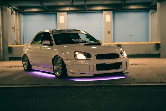 a car in a parking lot with purple underglow for are neon lights illegal in florida