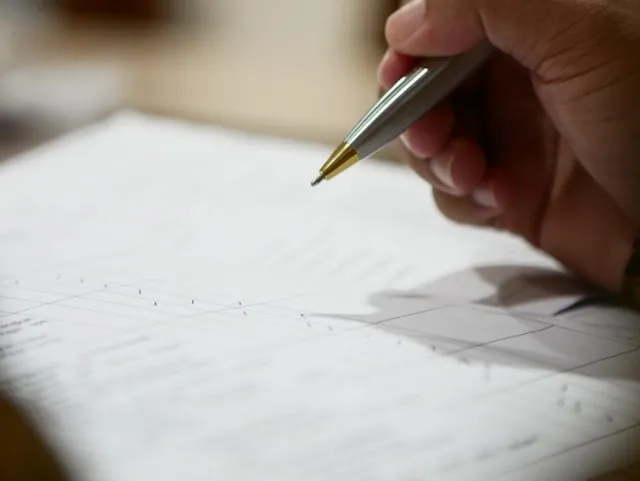 a person using a ballpoint pen to write notes for how to remove ballpoint ink from clothes