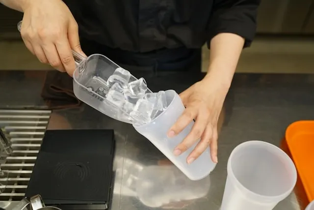 someone scooping ice into a tumbler for what is a tumbler