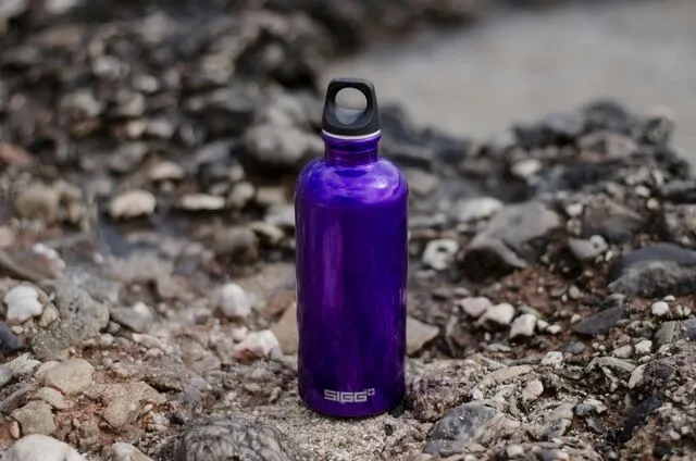 a purple water bottle on the beach for how often should you wash your water bottle
