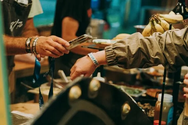 a person having their wristband checked for how to make rubber wristbands