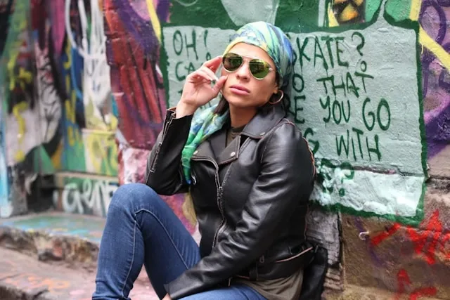 a person in a leather jacket wearing a headscarf for how to wear silk scarf on head