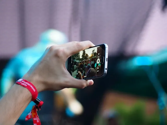 a person wearing a red wristband while holding a phone for wristbands material
