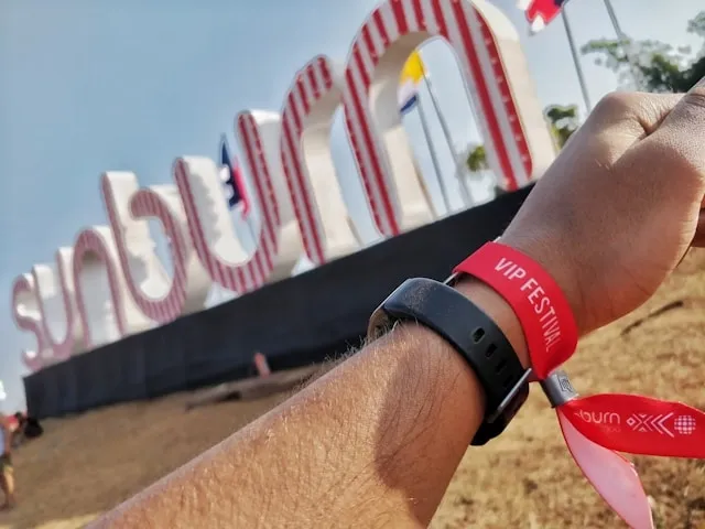 a person wearing a red festival wristband for how to take off festival wristband