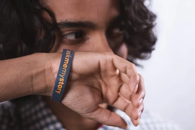 a person wearing a blue and orange wristband for wristbands material
